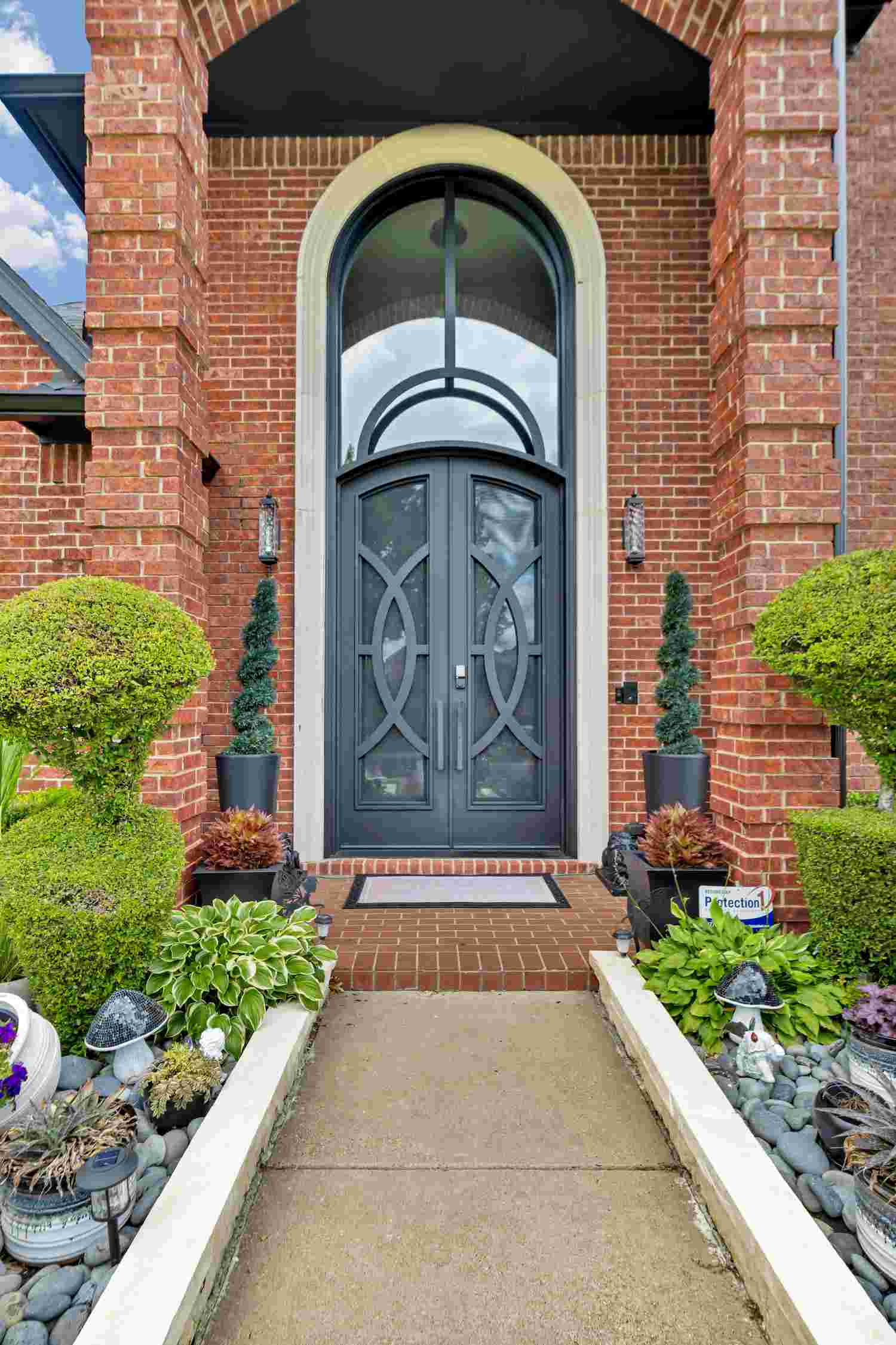 Arched wrought iron double entry door with transom window and decorative scrollwork