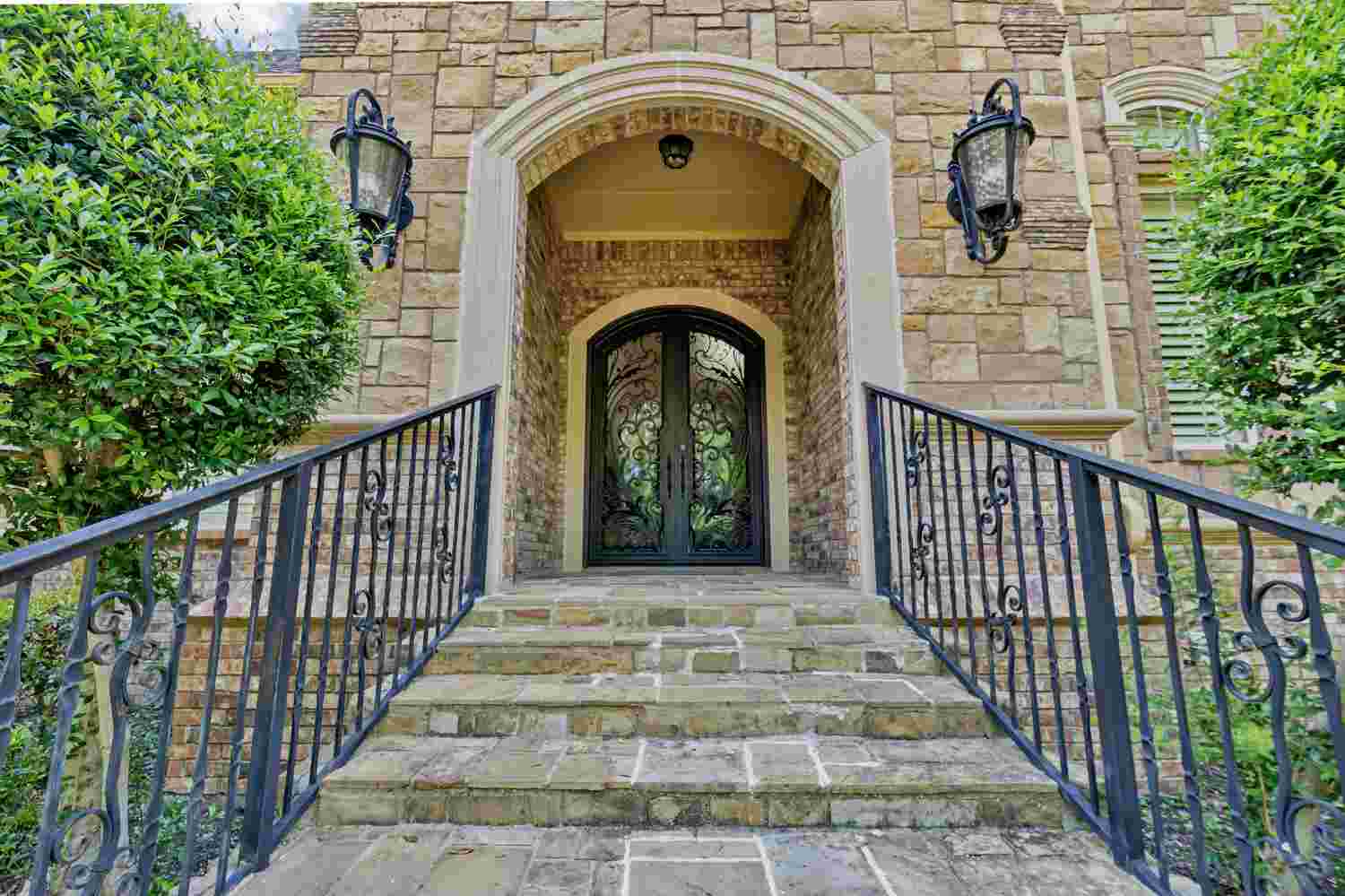 Traditional iron double door with arched top, black finish, and scrollwork