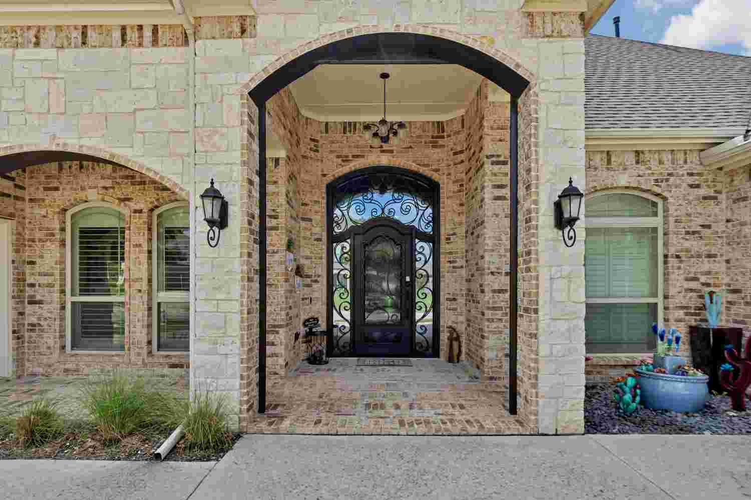 Traditional iron single door with arched top, black finish, and scrollwork