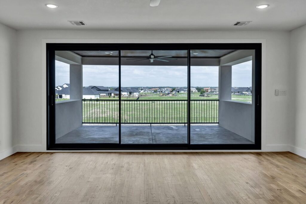Black framed sliding glass door with balcony view
