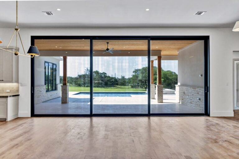 Black framed sliding glass door opening to the patio in a custom home