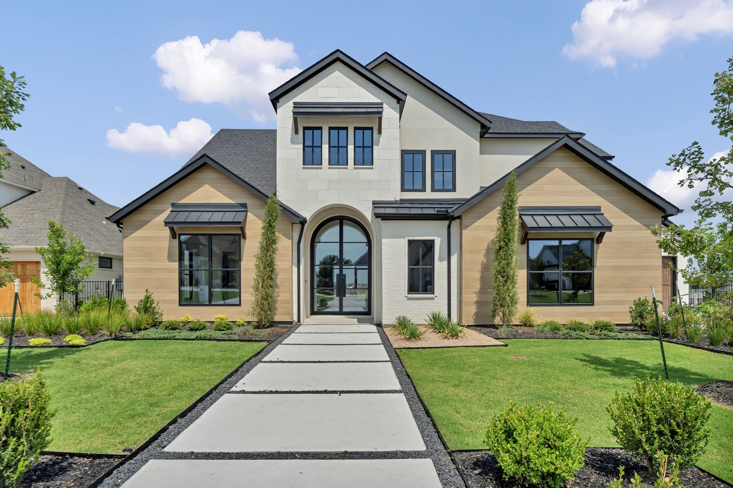 Custom steel arched entry door on a modern house exterior from Love That Door
