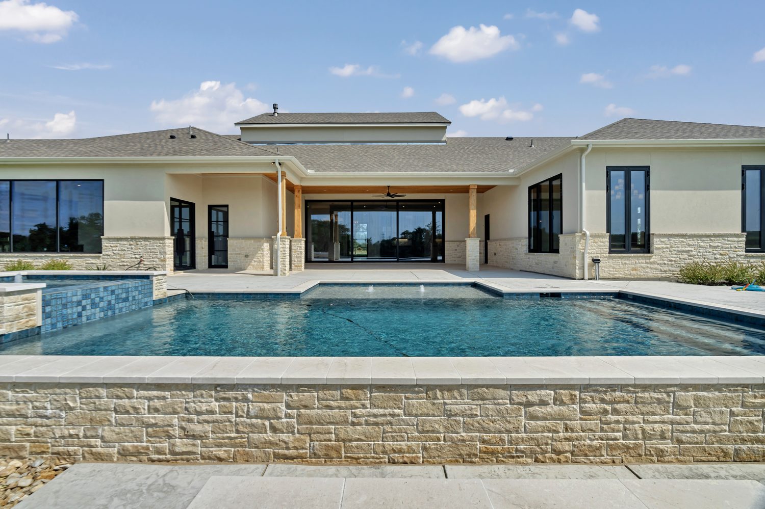 Modern house exterior with swimming pool and stone facade