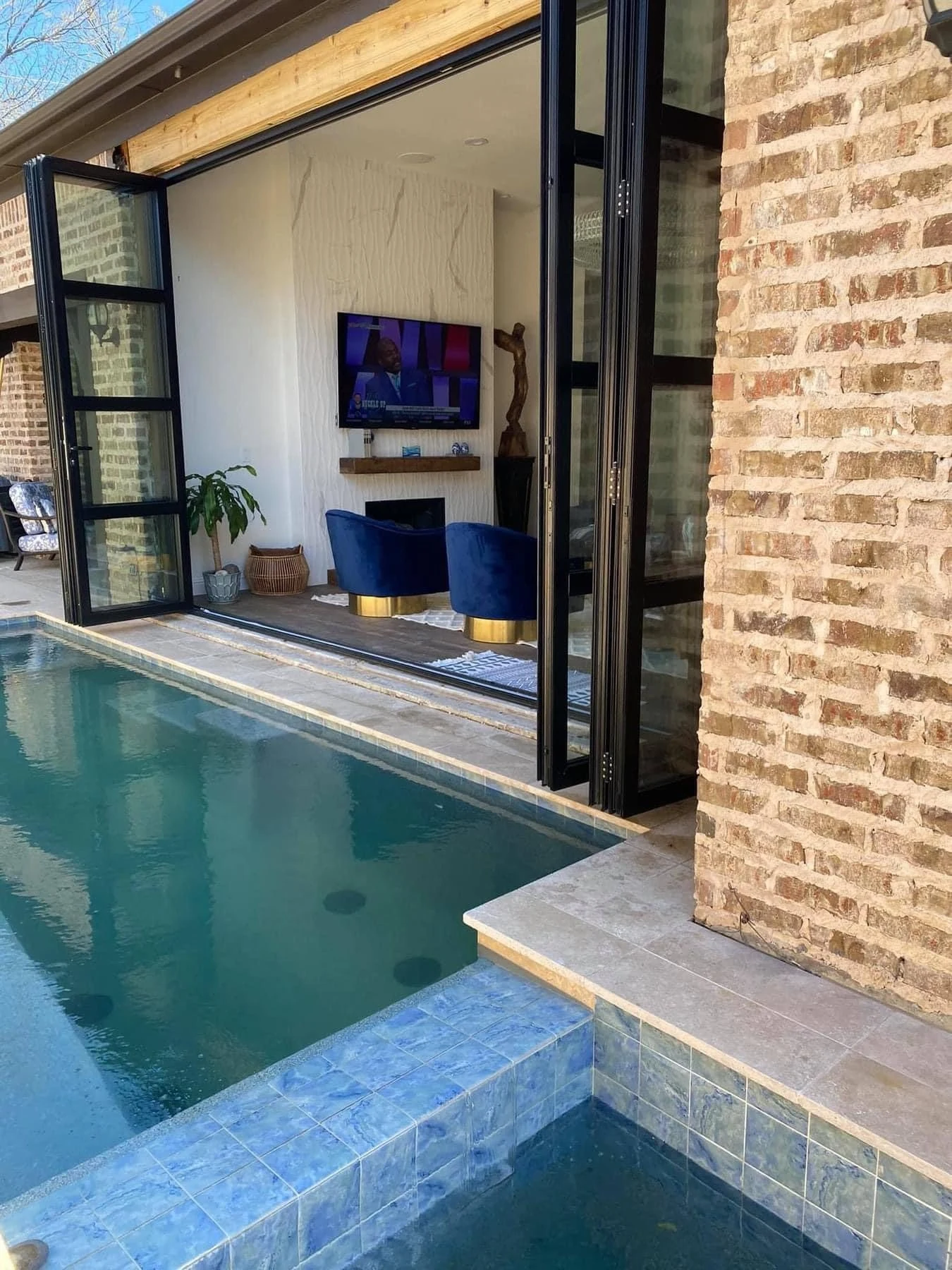 Aluminum four panel bifold door open to pool
