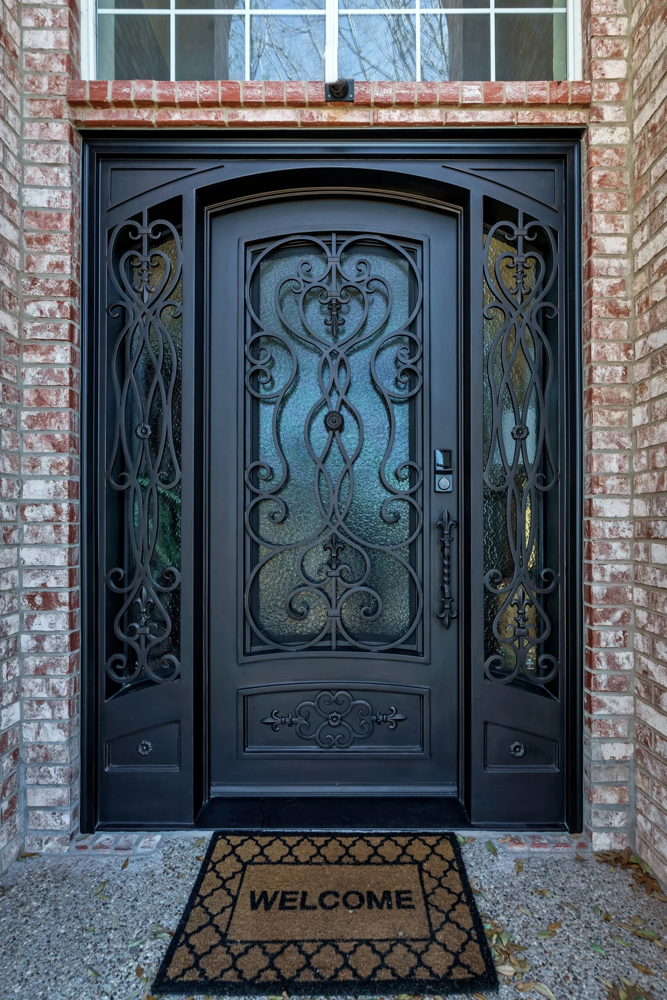Black steel double arched entry door with scrollwork, textured glass and sidelights